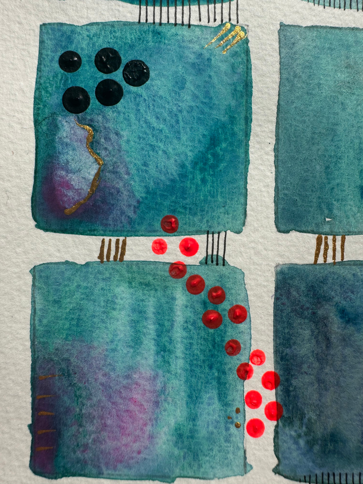 Close-up of teal squares with red dots and black stitched lines.