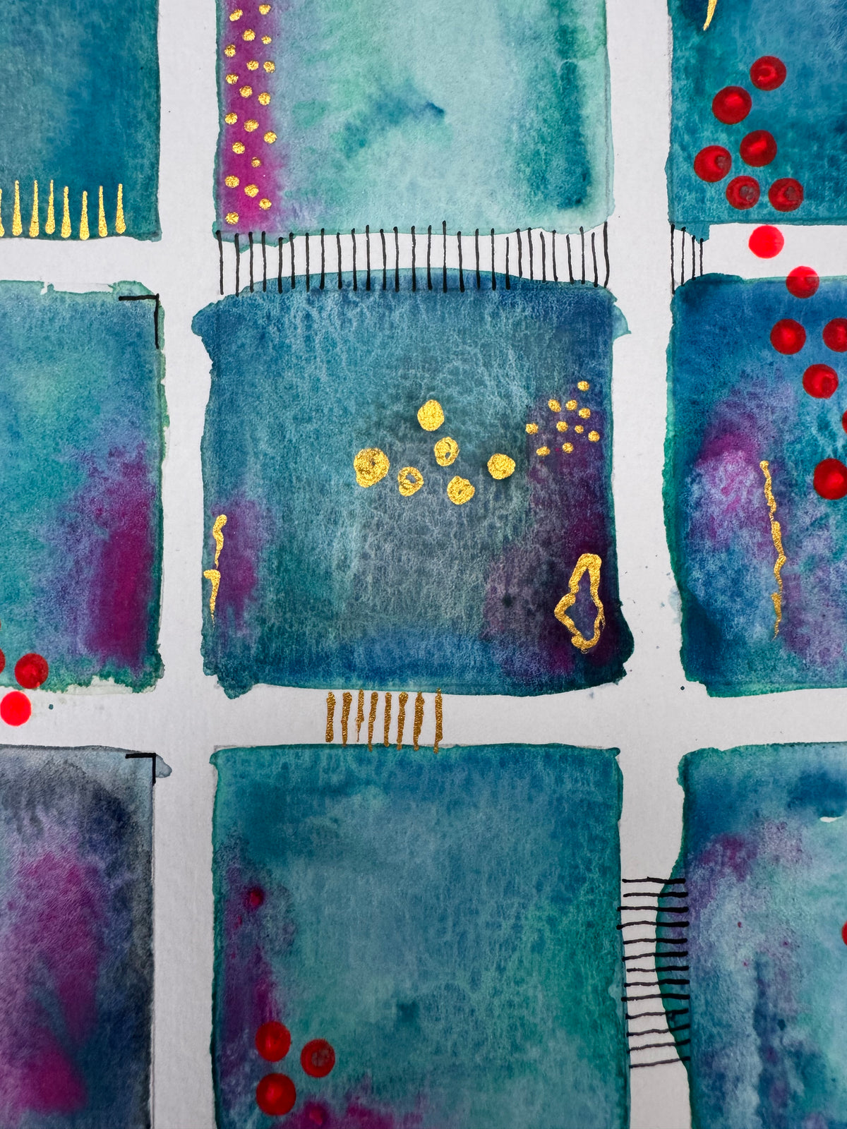 Close-up of teal squares with red dots and black stitched lines.