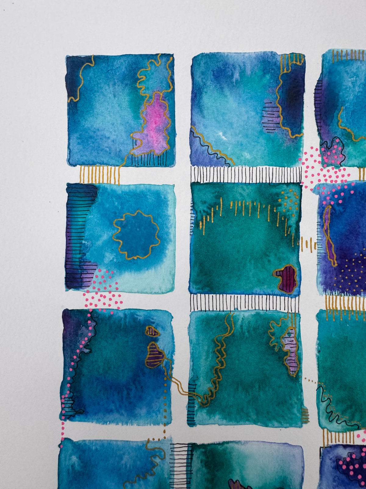 Watercolour painting of fifteen teal, blue and violet squares in a grid, linked by gold lines and black stitched marks, with clusters of pink dots.
